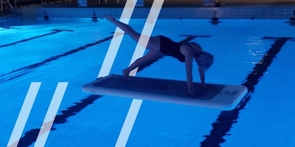 Vrouw doet oefening op een speciale yogamat op het water in een sfeervol verlicht zwembad