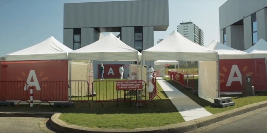 Een triagepunt in Antwerpen, met grote banners van stad Antwerpen en enkele witte tenten. Een triagepunt in Antwerpen, met grote banners van stad Antwerpen en enkele witte tenten.