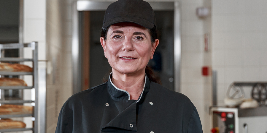 Een vrijwilliger poseert in een sociale bakkerij. Een vrijwilliger poseert in een sociale bakkerij.
