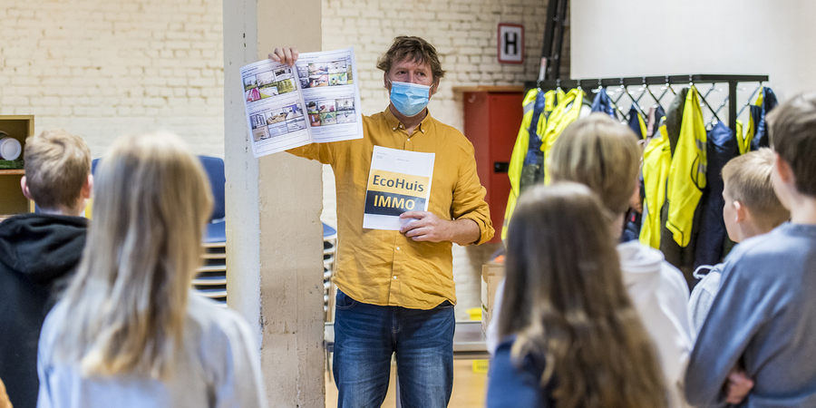 een begeleider met mondmasker geeft les aan kinderen een begeleider met mondmasker geeft les aan kinderen