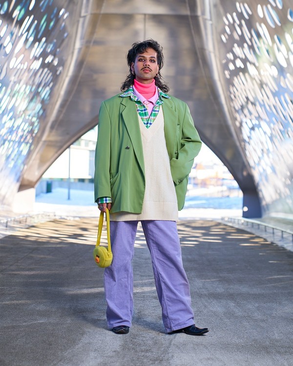 Amar poseert in kleurrijke outfit op de fietsersbrug aan Park Spoor Noord