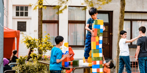 Jongen bouwt toren met bouwblokken