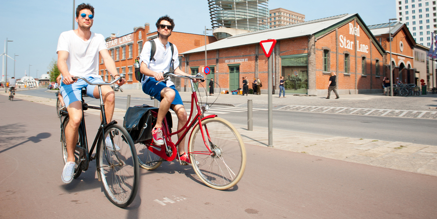 2 mannen fietsen op het fietspad langs het Red Star Line Museum. 2 mannen fietsen op het fietspad langs het Red Star Line Museum.