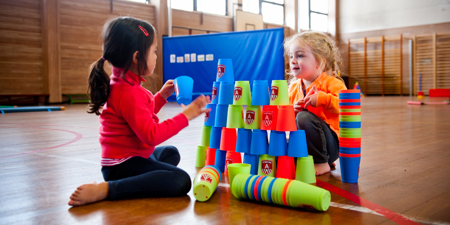 Twee meisjes bouwen een toren met stapelbekers