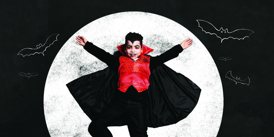 Kind verkleedt als Dracula met volle maan op achtergrond Kind verkleedt als Dracula met volle maan op achtergrond