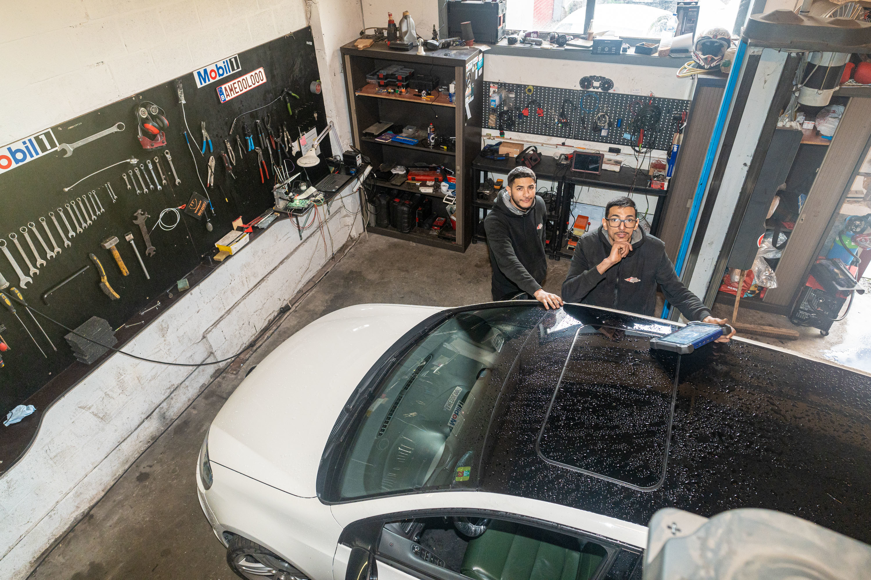 Hicham en Achmed in hun garage, foto genomen van bovenaan Hicham en Achmed in hun garage, foto genomen van bovenaan