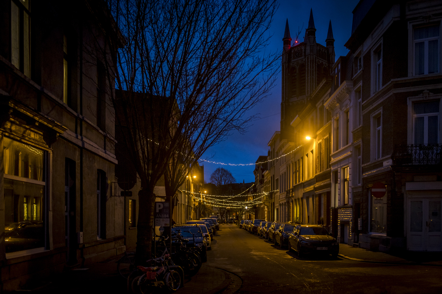 Berchemse straat in de schemer, versierd met lichtslingers
