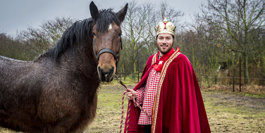 De ganzenkeizer in keizerlijke outfit naast zijn paard De ganzenkeizer in keizerlijke outfit naast zijn paard