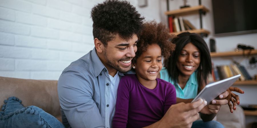 Man, vrouw en kind kijken op een tablet