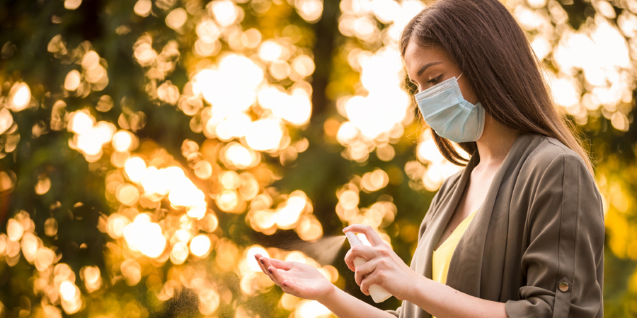 Vrouw met mondmasker die haar handen ontsmet Vrouw met mondmasker die haar handen ontsmet