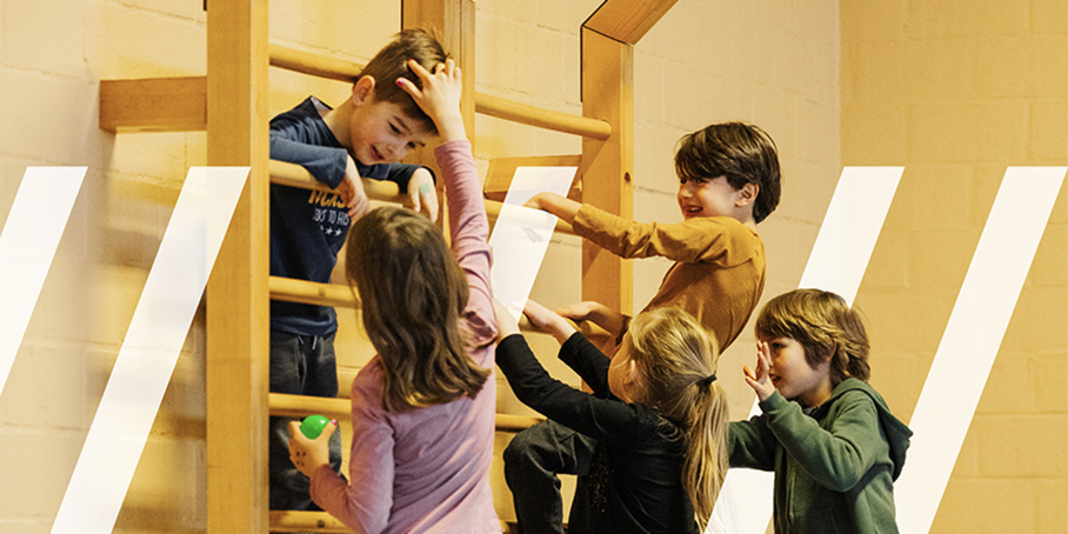 Kinderen hangen lachend aan het sportraam en hebben heel veel plezier