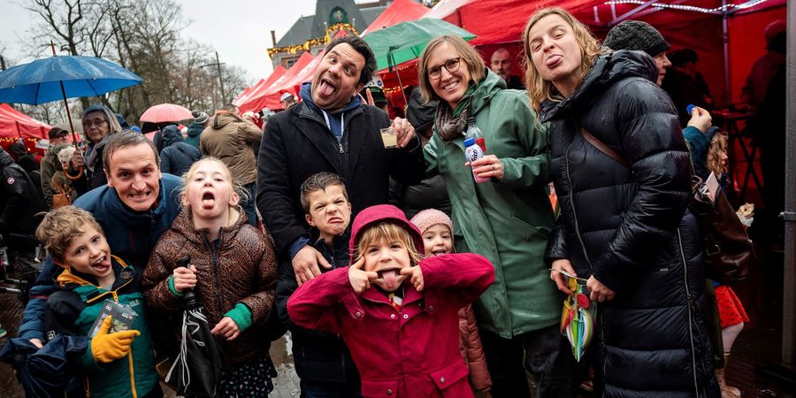 Enkele bezoekers van de kerstdrink trekken gekke bekken op de Wilrijkse kerstmarkt