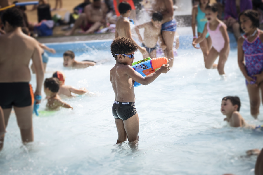 Een jongen staat met een waterpistool in het kinderbad van zwembad De Molen