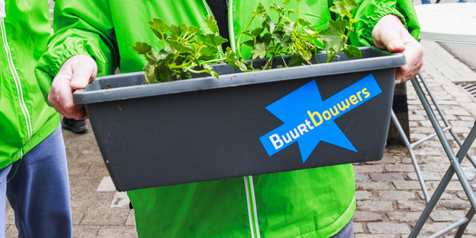Een bloembak met een sticker van Buurtbouwers