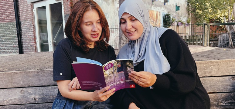 Sanne en Meriam bekijken samen het competentiekader.