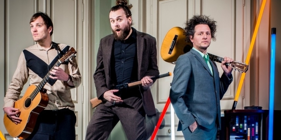 Drie mannen houden in een binnenruimte een muziekinstrument vast. Drie mannen houden in een binnenruimte een muziekinstrument vast.