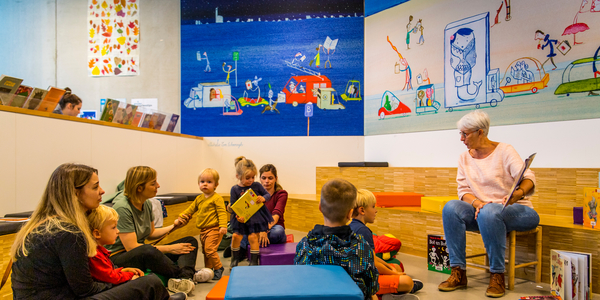 Een voorleesmoment met kinderen en hun ouders in de voorleeshoek van Bibliotheek Bist.