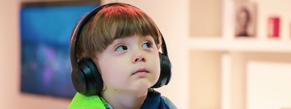 Jongen luistert naar een ingesproken boek Jongen luistert naar een ingesproken boek