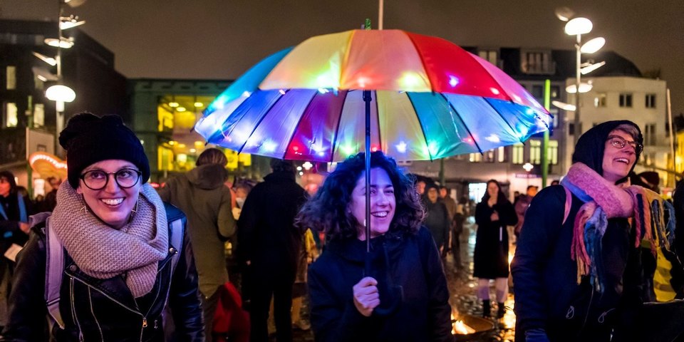 Noorderlicht deelnemers onder kleurrijke paraplu tijdens parade