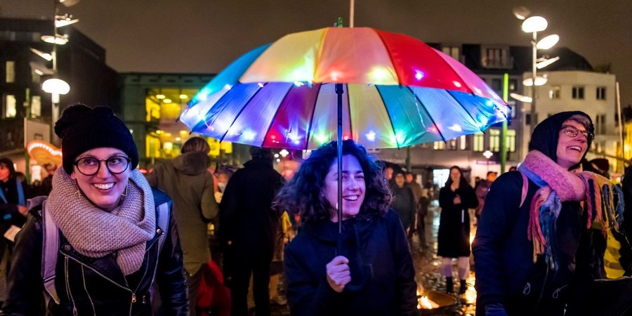 Noorderlicht deelnemers onder kleurrijke paraplu tijdens parade Noorderlicht deelnemers onder kleurrijke paraplu tijdens parade