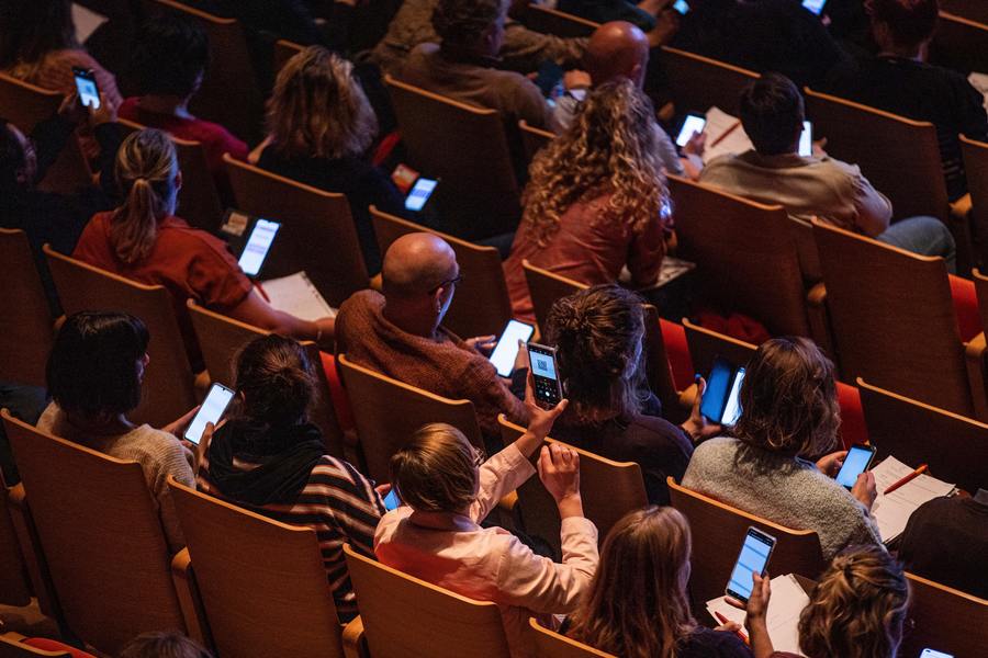 Deelnemers doen mee aan een quiz op hun smartphone tijdens een workshop.
