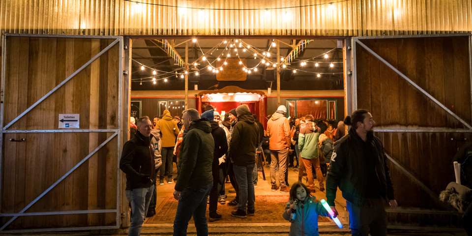 Evenementenloods met sfeerverlichting tijdens de avond.