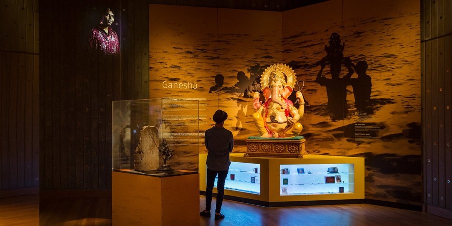 Een man kijkt in het MAS naar een beeld van de Indische godin Ganesha.