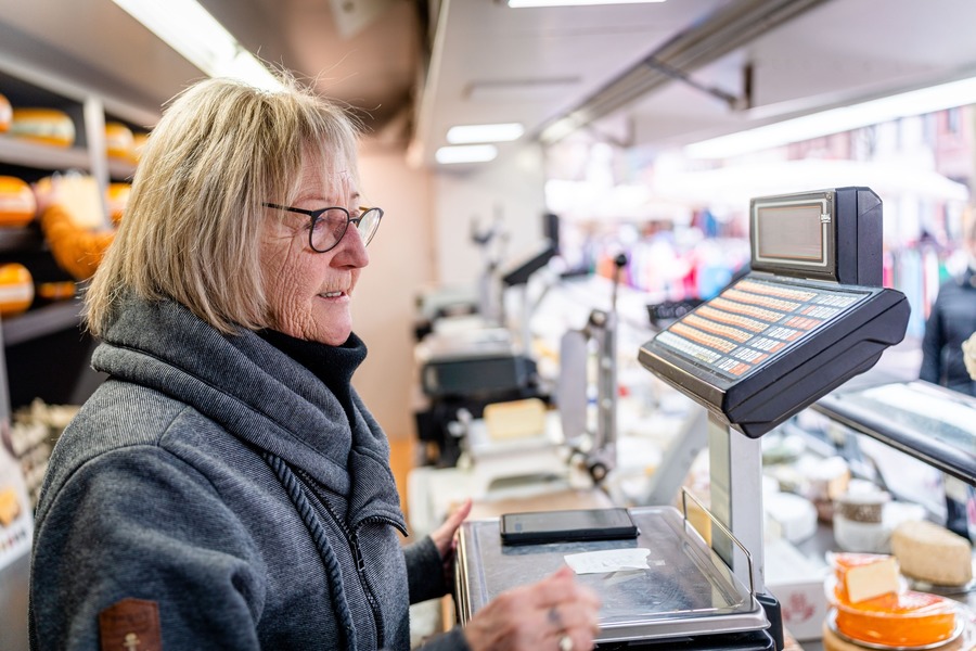 De mama van Ive achter de kassa