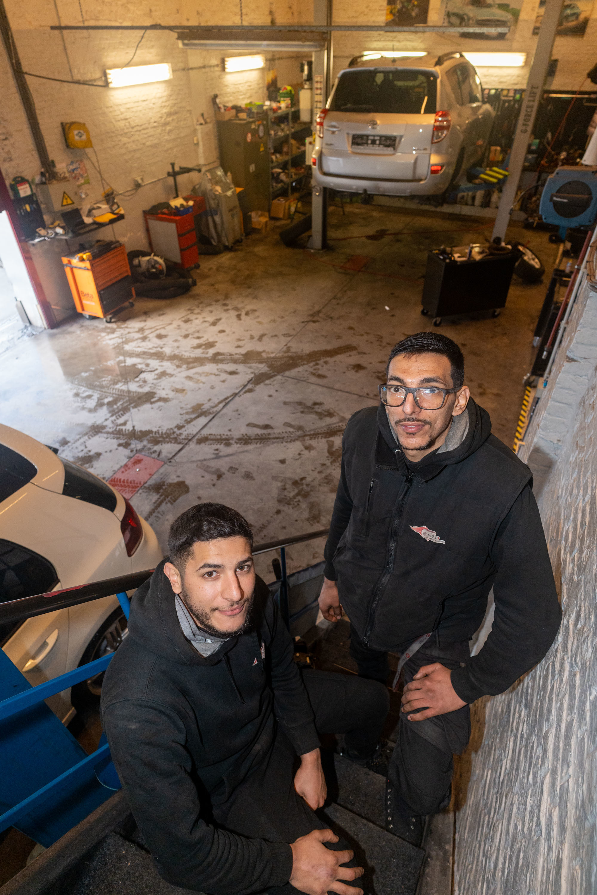 Het duo poseert op de trap in hun garage Het duo poseert op de trap in hun garage