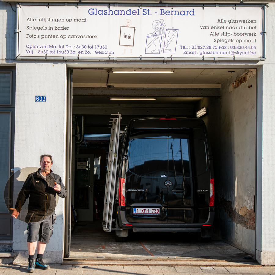 Eigenaar staat voor ingang glashandel Eigenaar staat voor ingang glashandel