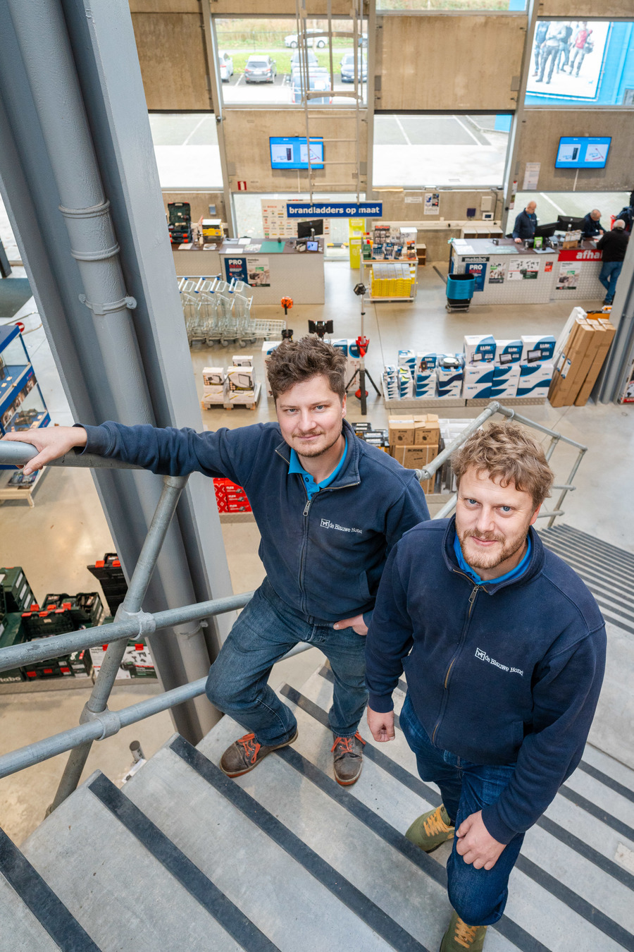 Alexander en Philip lopen de trap op in de winkel