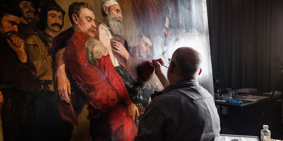 restaurator Marc Leenaerts restaureert het schilderij van Emile Godding.