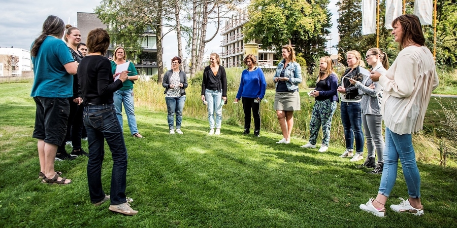 Een groep kinderbegeleiders volgen een workshop rond buitenactiviteiten Een groep kinderbegeleiders volgen een workshop rond buitenactiviteiten