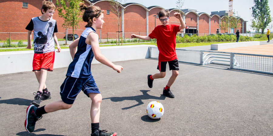 Drie kinderen voetballen op een pannavoetbalveldje in het Regatta Urban Sports Park in Antwerpen-Linkeroever.