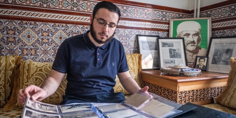 man bladert in een map met foto's