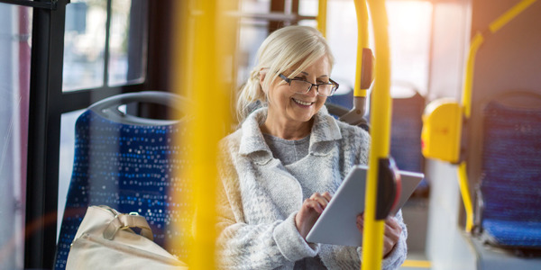 Dame met tablet op bus