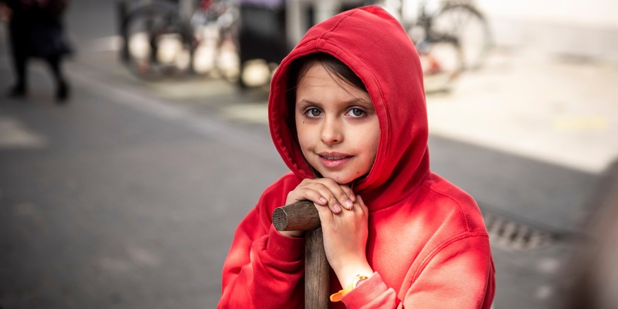 Meisje leunt op haar spade bij het aanleggen van een buurtboom