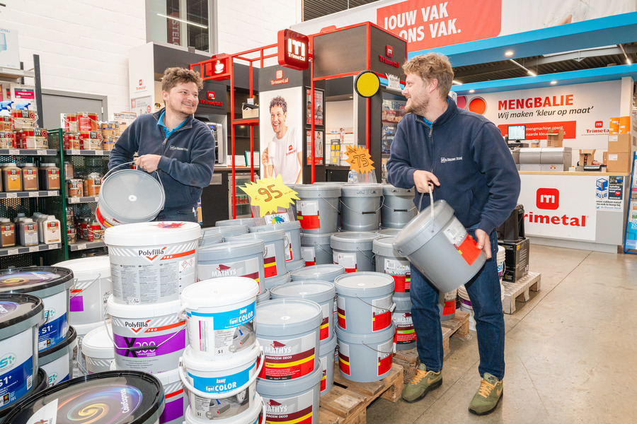 De zaakvoerders in de verfwinkel met beiden een pot verf in de hand