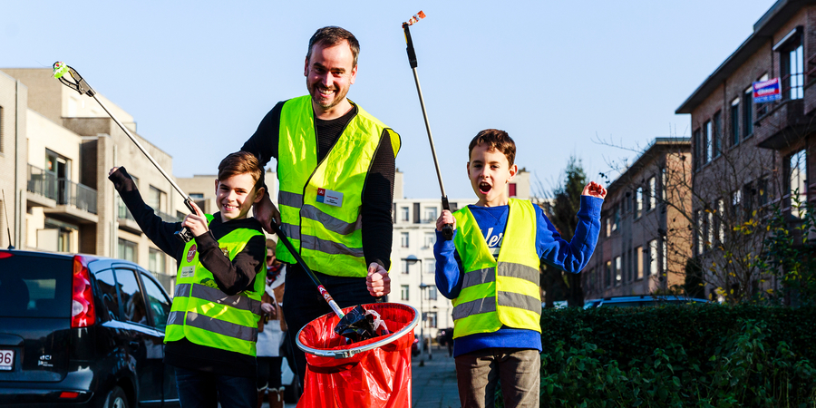 Man met twee kinderen ruimt zwerfvuil op. Man met twee kinderen ruimt zwerfvuil op.