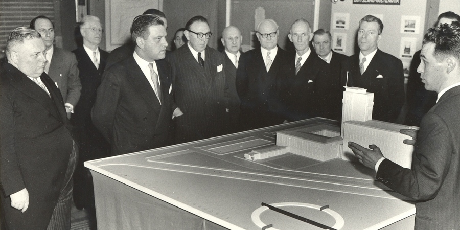 De maquette van het nieuwe gemeentehuis. Helemaal links  burgemeester Dequeecker, helemaal rechts Edward Van  Steenbergen junior.