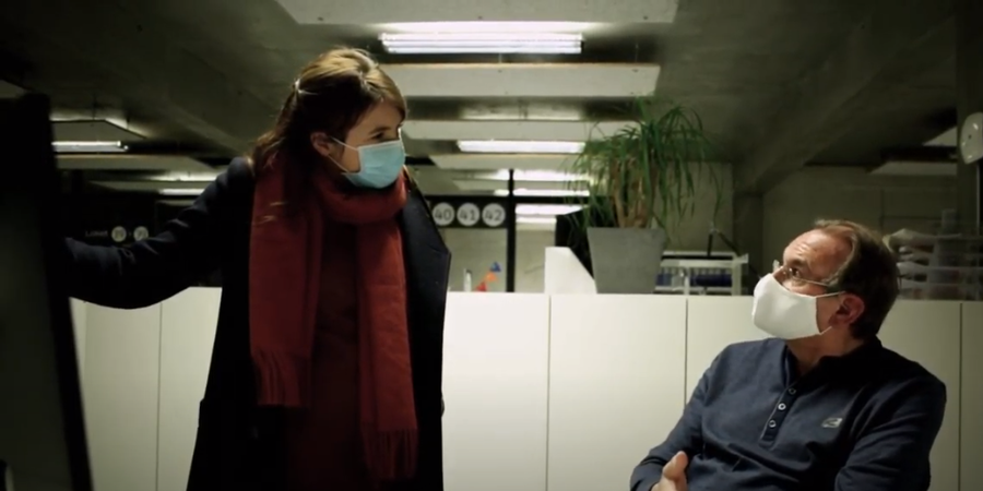 Een vrouw en een man praten binnen met elkaar. Een vrouw en een man praten binnen met elkaar.