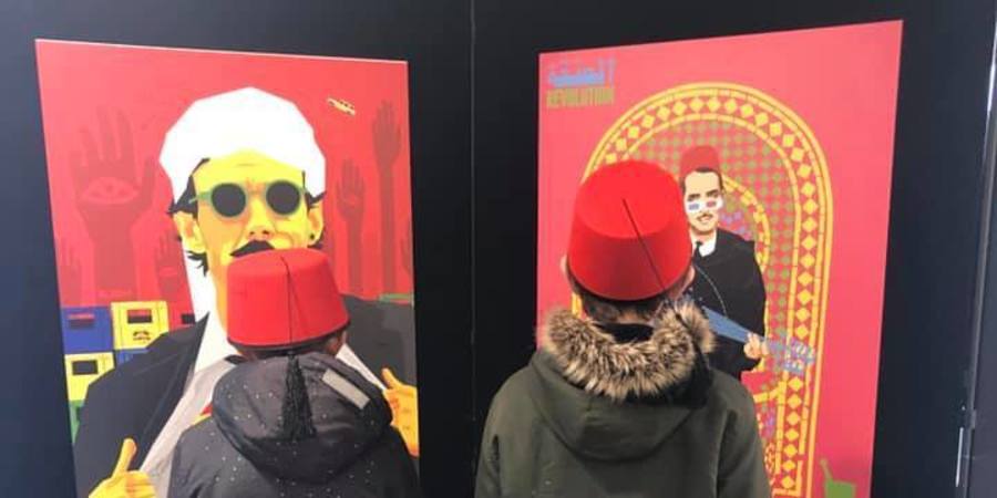 Twee kinderen met een rode fez-hoed op staan voor de kunstwerken Twee kinderen met een rode fez-hoed op staan voor de kunstwerken