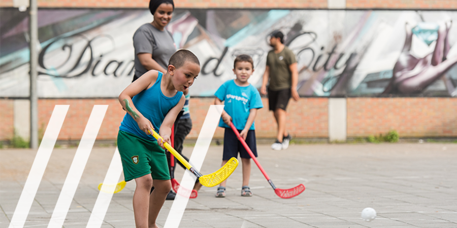Jongens spelen hockey op pleintjes