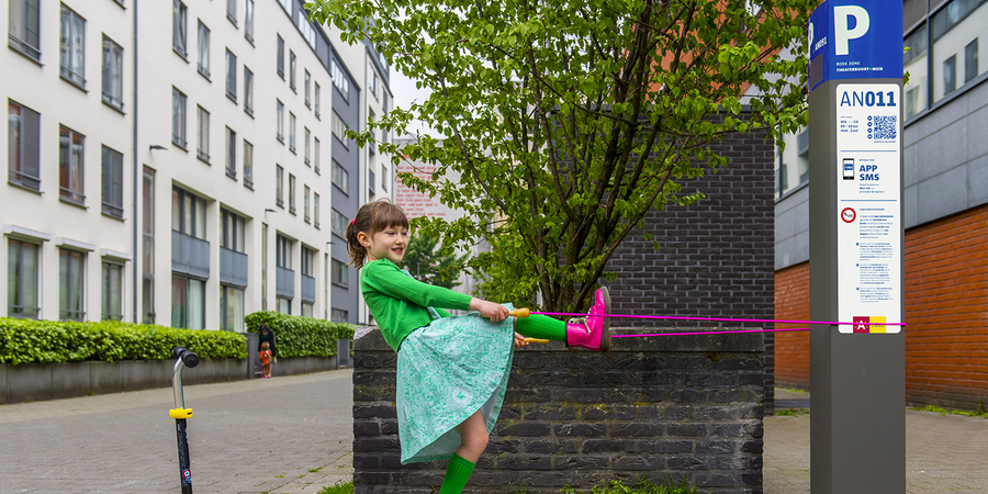 Meisje speelt met springtouw aan parkeerautomaat Meisje speelt met springtouw aan parkeerautomaat