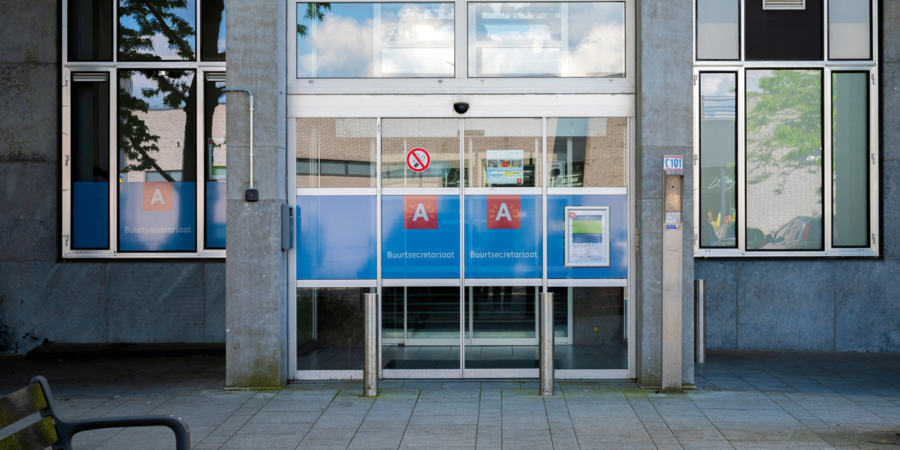 Gevel van buurtsecretariaat Merksem, blauwe stickers met A-logo op toegangsdeuren
