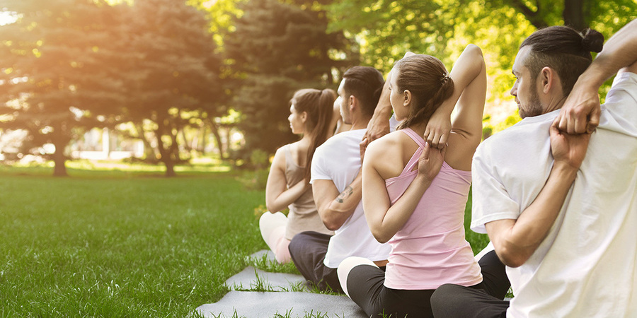 4 jonge mensen doen aan yoga in een park