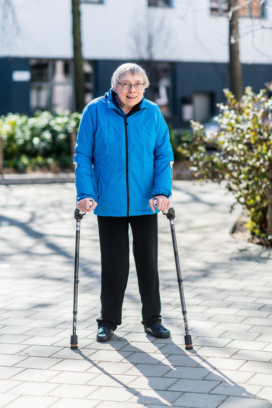 Ann poseert lachend, steunend op haar krukken naar de fotograaf Ann poseert lachend, steunend op haar krukken naar de fotograaf