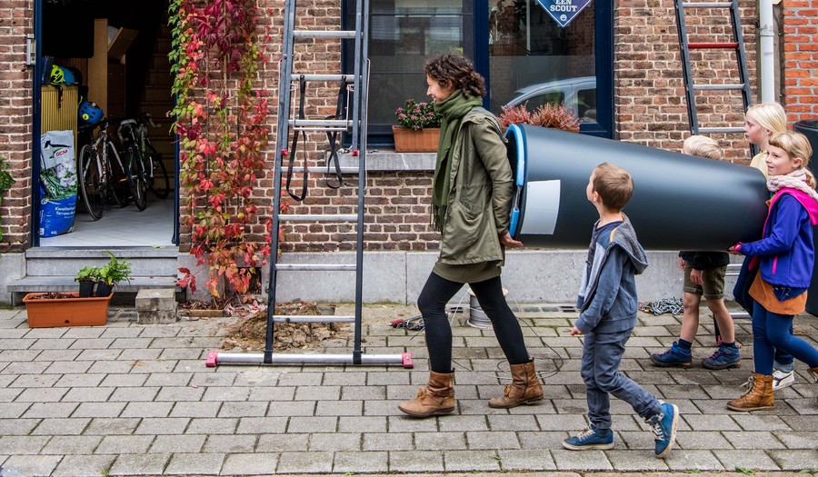 Bewoners dragen een regenton naar hun huis Bewoners dragen een regenton naar hun huis