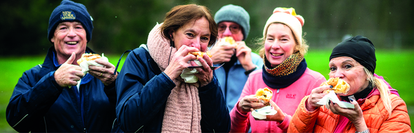 Deelnemers smullen na afloop van de jogging van een heerlijke appelbol.