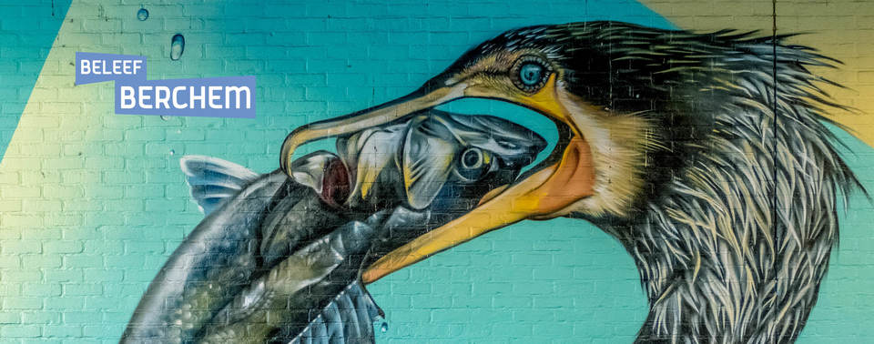 Graffitiwerk van een aalscholver die een vis opeet